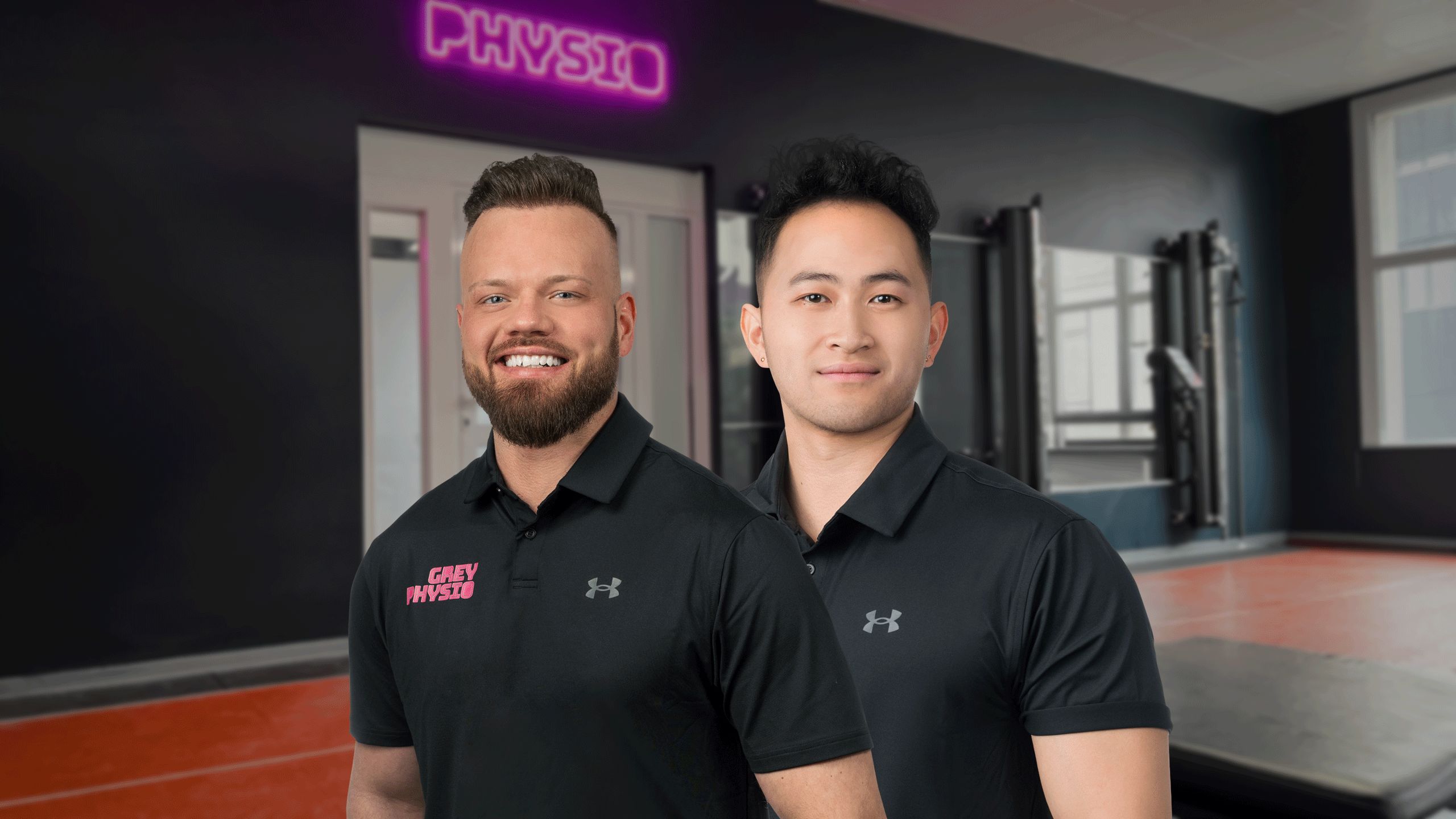 Das GREY PHYSIO Team unter der Physio-Neonschrift im GREY GYM